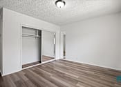 Thumbnail 5 of 23 - A room with a white wall and a wooden floor.