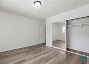 Thumbnail 8 of 23 - A room with a sliding door and wood flooring.