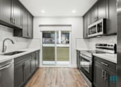 Thumbnail 12 of 23 - A modern kitchen with dark wood cabinets and stainless steel appliances.