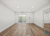 Thumbnail 13 of 23 - A room with wooden floors and white walls.