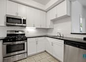 Thumbnail 36 of 65 - Kitchen with Stainless-Steel Stove, Microwave Oven, Dishwasher and Countertop Bar