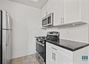 Thumbnail 50 of 65 - Kitchen with Stainless-Steel Refrigerator, Stove, and Microwave Oven