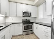 Thumbnail 7 of 38 - Kitchen with Stone Countertops, Stainless-Steel Appliances, and Ample Cabinet Storage