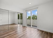 Thumbnail 52 of 71 - Bedroom with Mirrored Closet, Balcony, and Vinyl Flooring