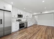 Thumbnail 49 of 124 - a renovated kitchen with white cabinets and stainless steel appliances