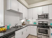 Thumbnail 6 of 38 - Kitchen with Stainless-Steel Dishwasher, Stove, and Microwave Oven