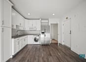 Thumbnail 35 of 48 - A kitchen with white cabinets and a washer and dryer in it.