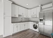 Thumbnail 36 of 48 - A modern kitchen with white cabinets and stainless steel appliances.