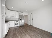 Thumbnail 30 of 48 - A kitchen with white cabinets and stainless steel appliances.