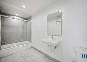 Thumbnail 34 of 48 - A bathroom with a white sink and a glass shower stall.
