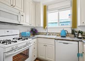 Thumbnail 4 of 65 - A kitchen with white appliances and cabinets.