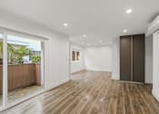 Thumbnail 35 of 39 - Living Room Area with Vinyl Flooring, Wall Heater, and Sliding Glass Door to Access Patio