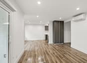 Thumbnail 34 of 39 - Living Room Area with Vinyl Flooring, Wall Heater, and Patio Entrance