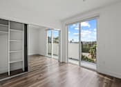 Thumbnail 25 of 71 - Bedroom with Large-Size Mirrored Closet with Shelving, Vinyl Flooring, and Balcony