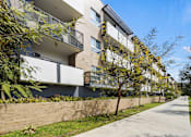 Thumbnail 48 of 49 - A modern apartment building with balconies and a sidewalk.