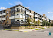 Thumbnail 47 of 49 - Apartment building with balconies and a clear sky.