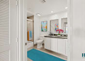 Thumbnail 10 of 49 - A bathroom with a toilet, sink, and mirror.