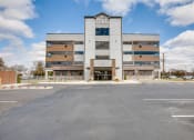 Thumbnail 15 of 31 - a large building with a parking lot in front of it
