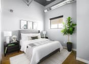 Thumbnail 26 of 31 - a bedroom with a white bed and a potted plant