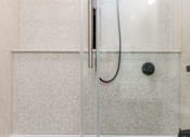 Thumbnail 18 of 33 - A shower door with a black handle and a black drain plug.
