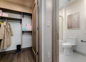 Thumbnail 6 of 33 - A bathroom with a toilet and a coat hanging up.