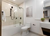 Thumbnail 3 of 33 - A white toilet in a modern bathroom with a glass shower.