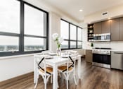Thumbnail 9 of 33 - A modern kitchen with a dining table set for two.