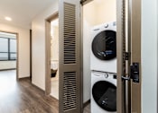Thumbnail 13 of 33 - A modern laundry room with a washer and dryer.