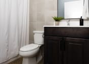 Thumbnail 7 of 31 - a bathroom with a toilet and a sink and a shower curtain