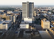 Thumbnail 1 of 33 - A cityscape with a tall building in the center and a sign that reads 