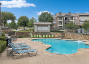 Thumbnail 9 of 15 - Pool with lounge chairs at Cypress View Villa Apartments in Weatherford TX