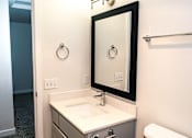 Thumbnail 8 of 17 - A bathroom with a sink, mirror, and towel rack.