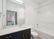 Thumbnail 37 of 43 - A white bathroom with a toilet, sink, and bathtub.