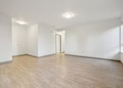 Thumbnail 11 of 43 - A room with wooden flooring and a door in the middle.