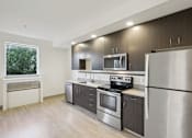 Thumbnail 6 of 43 - A modern kitchen with stainless steel appliances and wooden cabinets.