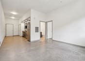 Thumbnail 26 of 43 - A large empty room with a door on the left and a door on the right.