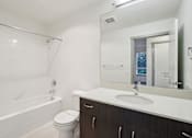 Thumbnail 14 of 43 - A white bathroom with a toilet, sink, and bathtub.