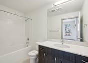 Thumbnail 36 of 43 - A white bathroom with a sink, toilet, and bathtub.