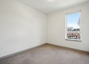 Thumbnail 21 of 43 - A room with a window showing a view of a building outside.