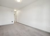 Thumbnail 17 of 43 - A large empty room with a door on the left side.