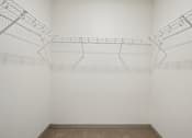Thumbnail 23 of 43 - A white wire shelf in a white room with a brown floor.