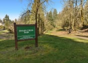 Thumbnail 37 of 42 - a sign for singer creek park next to a dirt road