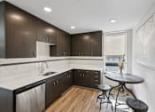 Thumbnail 40 of 43 - A modern kitchen with dark wood cabinets and a white countertop.