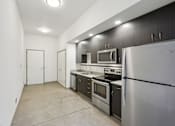 Thumbnail 24 of 43 - A kitchen with stainless steel appliances and a white refrigerator.