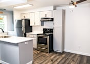 Thumbnail 6 of 17 - A kitchen with a black refrigerator, stove, and oven.