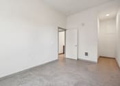 Thumbnail 31 of 43 - A large empty room with a doorway leading to another room.