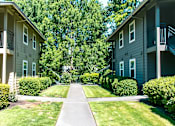 Thumbnail 14 of 17 - A pathway leads between two similar buildings with balconies.