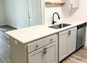 Thumbnail 15 of 17 - A kitchen with white cabinets and a sink.