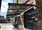 Thumbnail 10 of 11 - awning over the front of a building with a stop sign