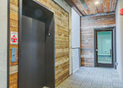 Thumbnail 5 of 11 - the entrance to a building with a black door and a wooden wall